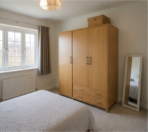 Freestanding two-door wardrobe before bespoke fitted install
