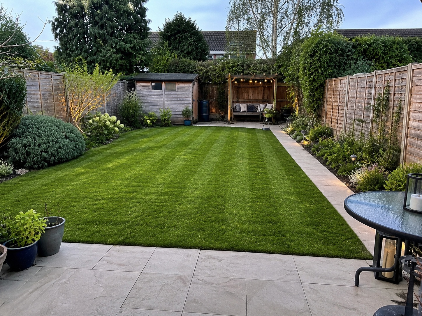 Illustrative AI mock-up of the same garden with a smart paved patio area and tidy planted borders